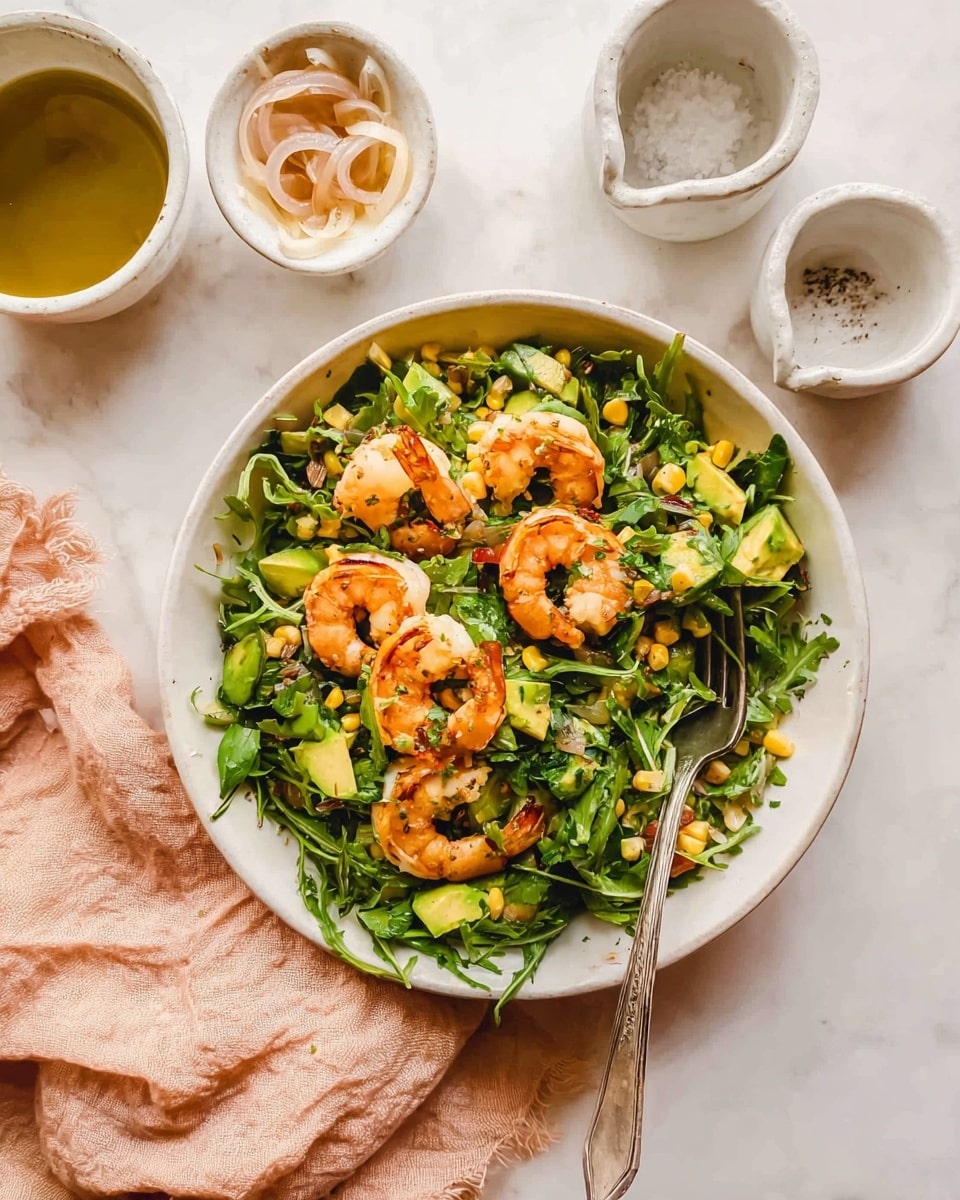 A white shallow bowl holds a fresh shrimp salad with five cooked shrimp placed on top, their orange-pink shells contrasting with the bright green arugula leaves underneath. Mixed throughout the greens are sliced avocado pieces, yellow corn kernels, and bits of herbs, giving a mix of yellow, green, and orange colors. A silver fork rests inside the bowl on the right side. Around the bowl are three small white ceramic containers, one with salt, one with olive oil, and one with thin sliced shallots. The background is a white marbled surface with a soft textured light peach cloth nearby. Photo taken with an iphone --ar 4:5 --v 7