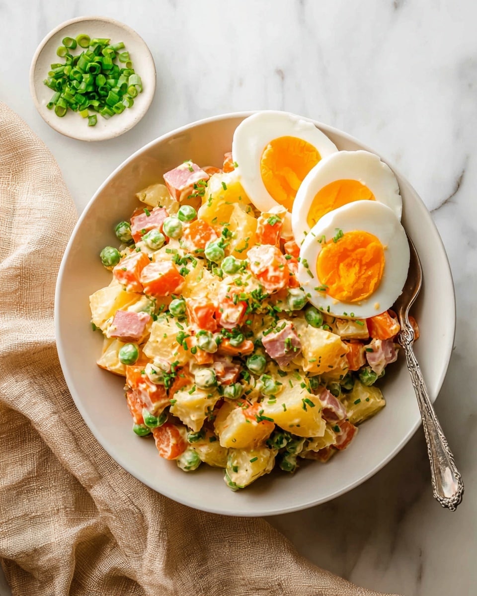 A white bowl filled with a mixed salad that has visible chunks of yellow potatoes, orange carrots, light pink ham, and small green peas, all coated in a creamy dressing. Three slices of hard-boiled egg with bright orange yolks are layered on top of the salad on one side. Finely chopped green onions are sprinkled over the salad and eggs. A silver fork rests inside the bowl, partially under the egg slices. Near the bowl, there is a small round white dish with extra chopped green onions, all placed on a white marbled surface with a light beige cloth loosely arranged nearby. photo taken with an iphone --ar 4:5 --v 7
