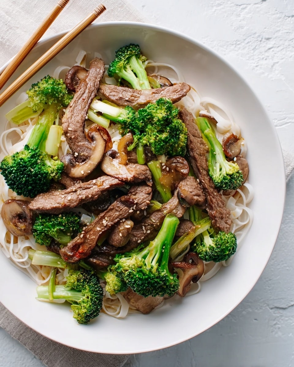 A white bowl holds a dish with white noodles at the bottom, topped with green broccoli florets and light green stalks placed around the edges. On top of the vegetables, there are several long, thin strips of cooked beef with a brownish color and a slight shine. Small, round, light brown mushrooms fill the spaces between the beef and broccoli. The bowl sits on a white marbled surface, with pale wooden chopsticks resting at the top edge. Photo taken with an iphone --ar 4:5 --v 7