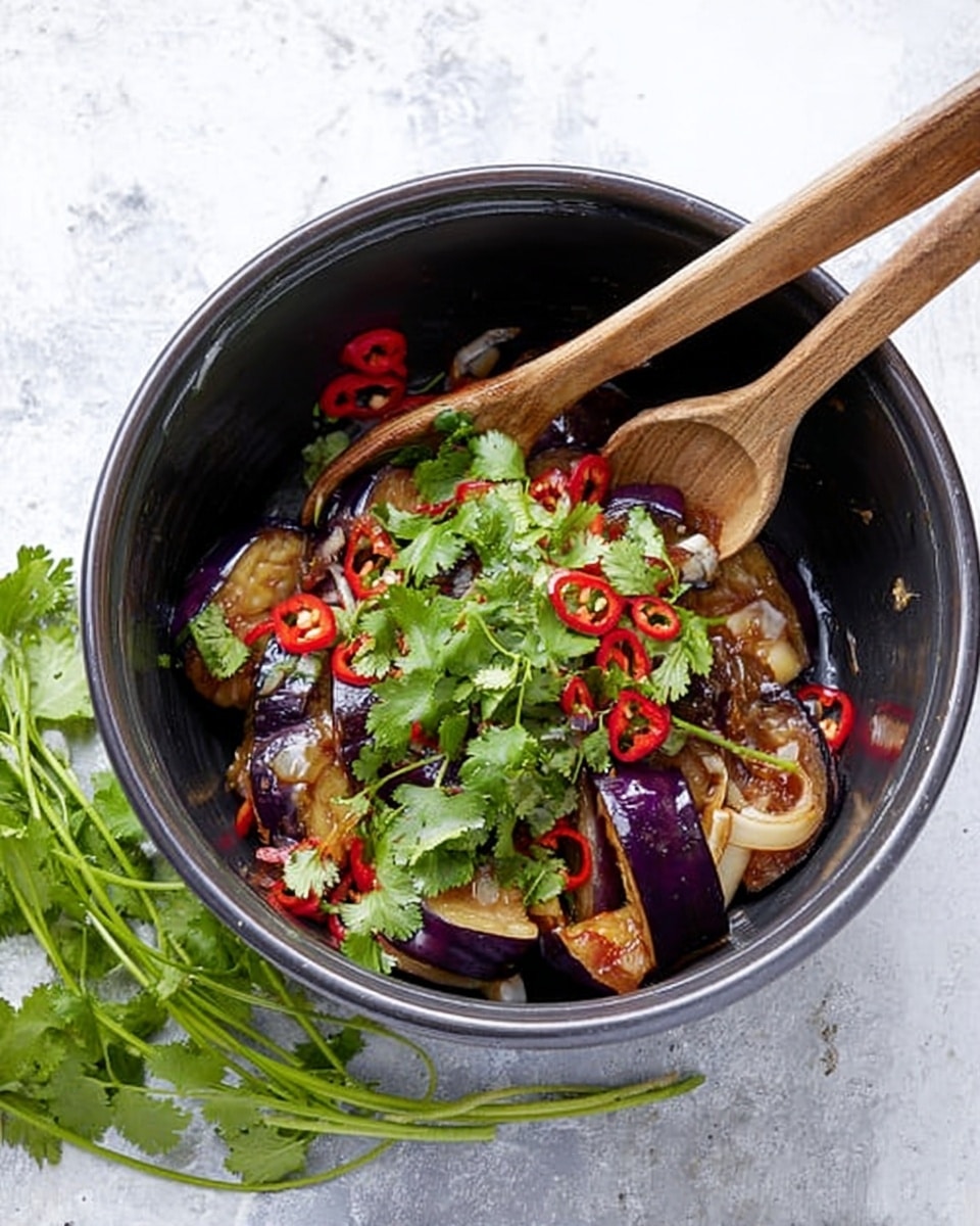 The image shows a black mixing bowl filled with several layers of ingredients. At the bottom, there are thick slices of dark purple eggplants with a soft texture. On top of them are sliced red chili peppers adding a bright red color, and scattered fresh green coriander leaves adding a fresh green touch. Light brown thin slices of ginger are also mixed in, creating thin layered rings. Two wooden spoons rest in the bowl. Fresh coriander sprigs are placed next to the bowl on a white marbled surface. Photo taken with an iphone --ar 4:5 --v 7