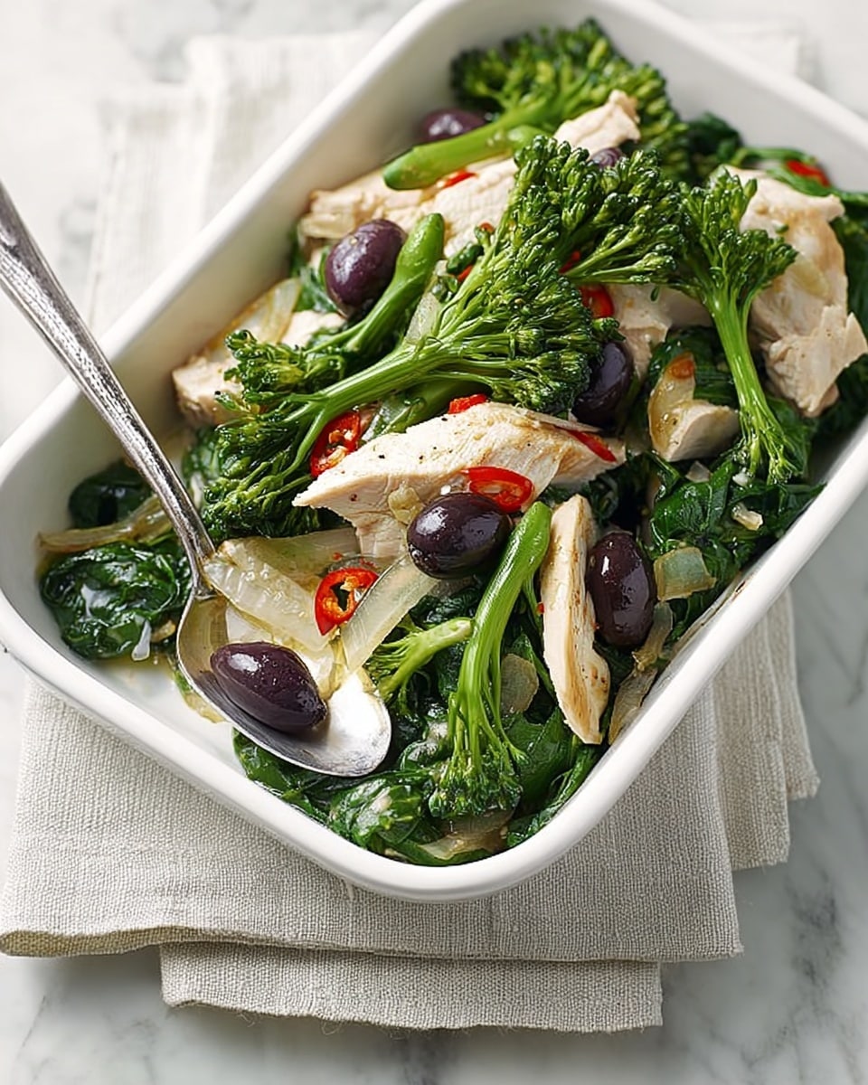 The image shows a white rectangular bowl filled with a fresh salad. The salad has several layers including chopped green kale, light beige pieces of cooked chicken breast, black olives, and thin red chili slices scattered through. A large silver spoon is resting inside the bowl on the left side, and the bowl is placed on folded beige cloths sitting on a white marbled surface. photo taken with an iphone --ar 4:5 --v 7