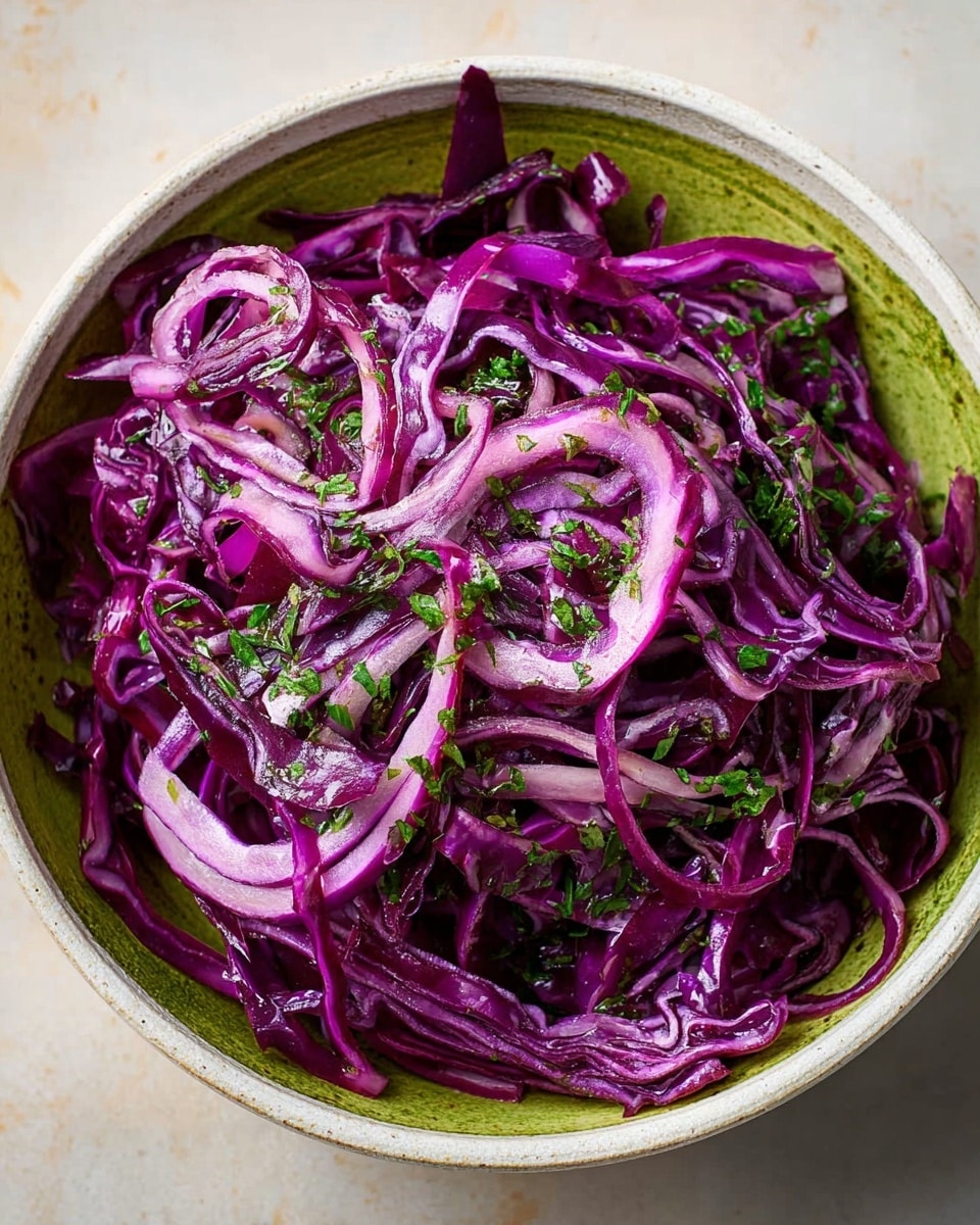A bowl filled with finely sliced purple cabbage, each thin strip showing deep violet color with a glossy texture, mixed with small pieces of fresh green herbs sprinkled evenly on top and throughout. The bowl is white and ceramic, set on a white marbled background with light shadows that enhance the vibrant colors of the cabbage and herbs. The cabbage is arranged loosely, giving a sense of freshness and crunchiness. photo taken with an iphone --ar 4:5 --v 7